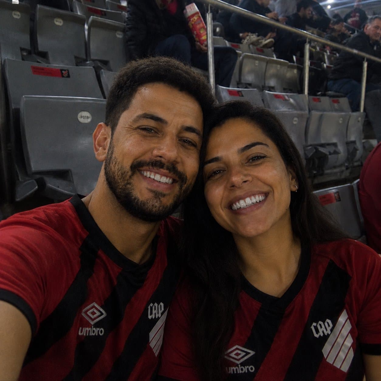 Matheus e Luana no estádio com camisa do Athletico